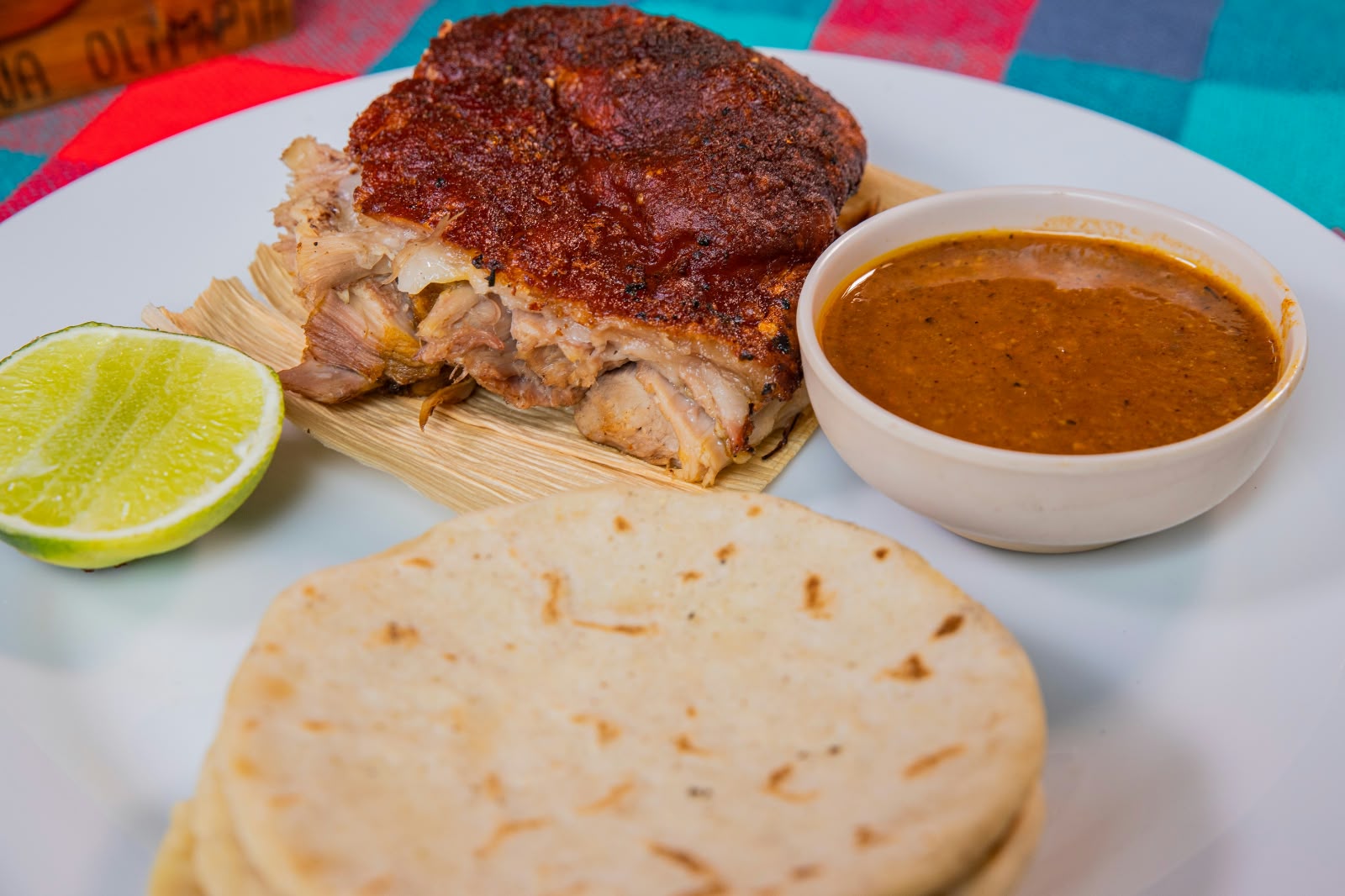 Detalle de cerdito horneado crujiente con tortilla y salsa