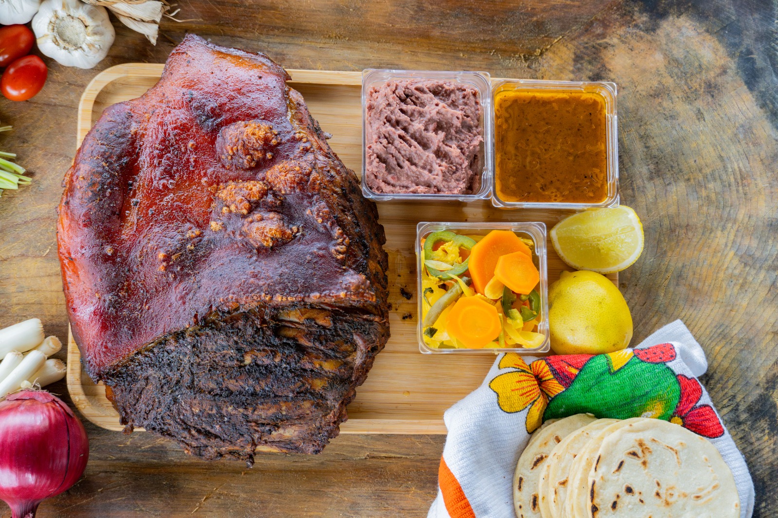 Cerdito horneado, frijoles, encurtido, salsa y tortillas
